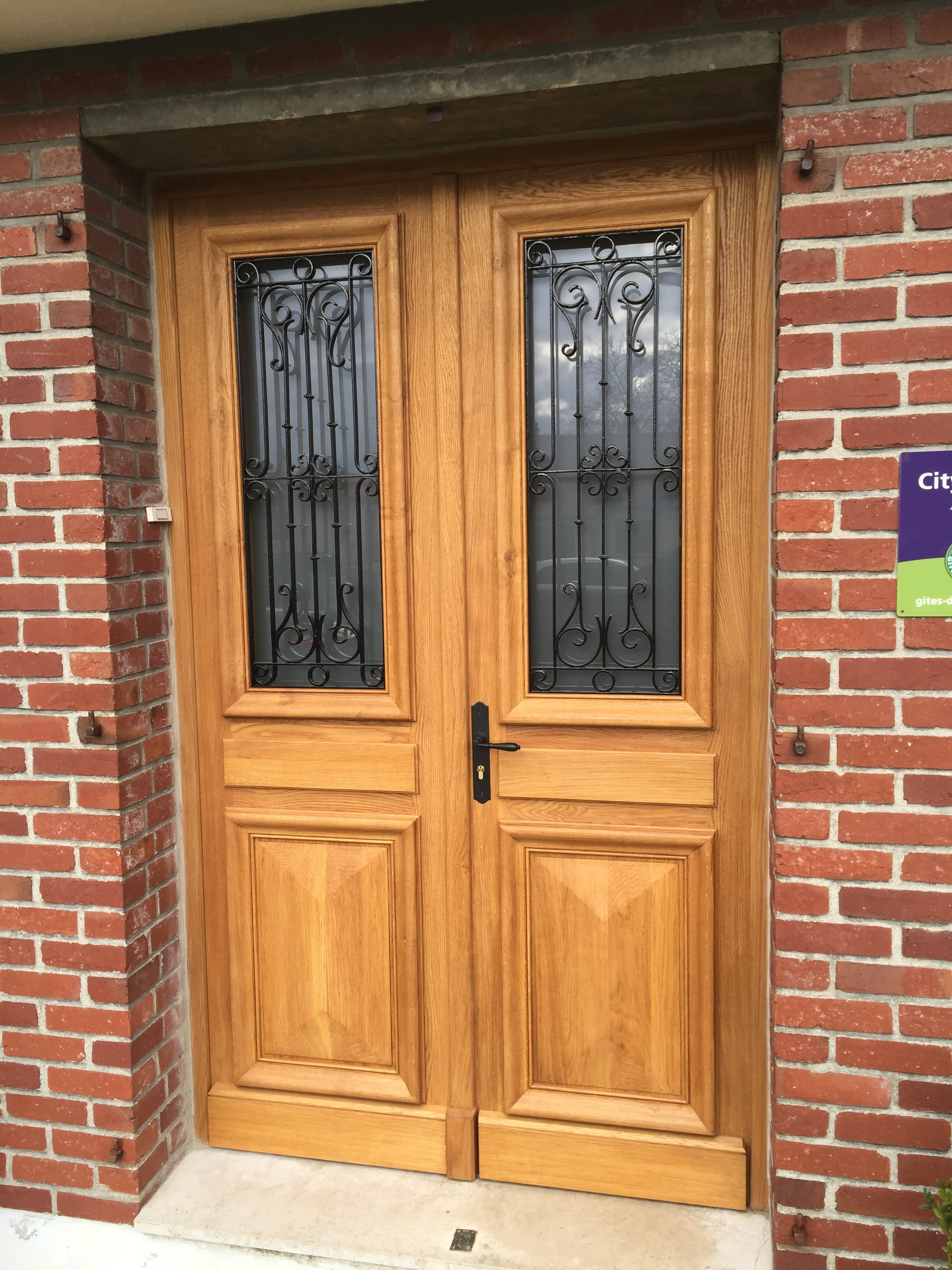 Porte d'entrée deux vantaux avec des grilles